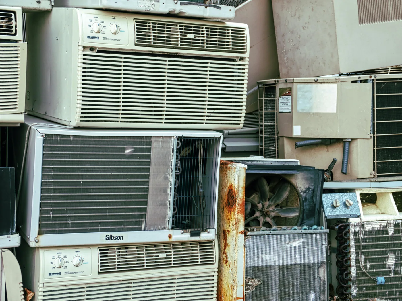 Stacked old air-conditioner units and appliances ready for removal and recycling