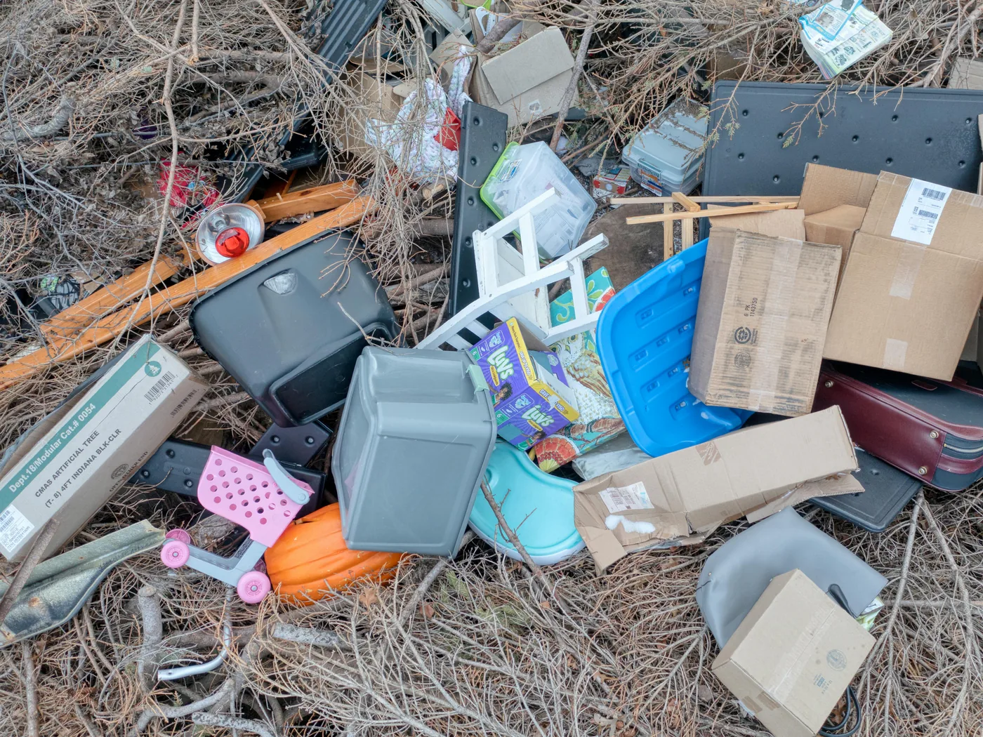 Pile of mixed household clutter — boxes, suitcase, toys, and bins ready for haul-off