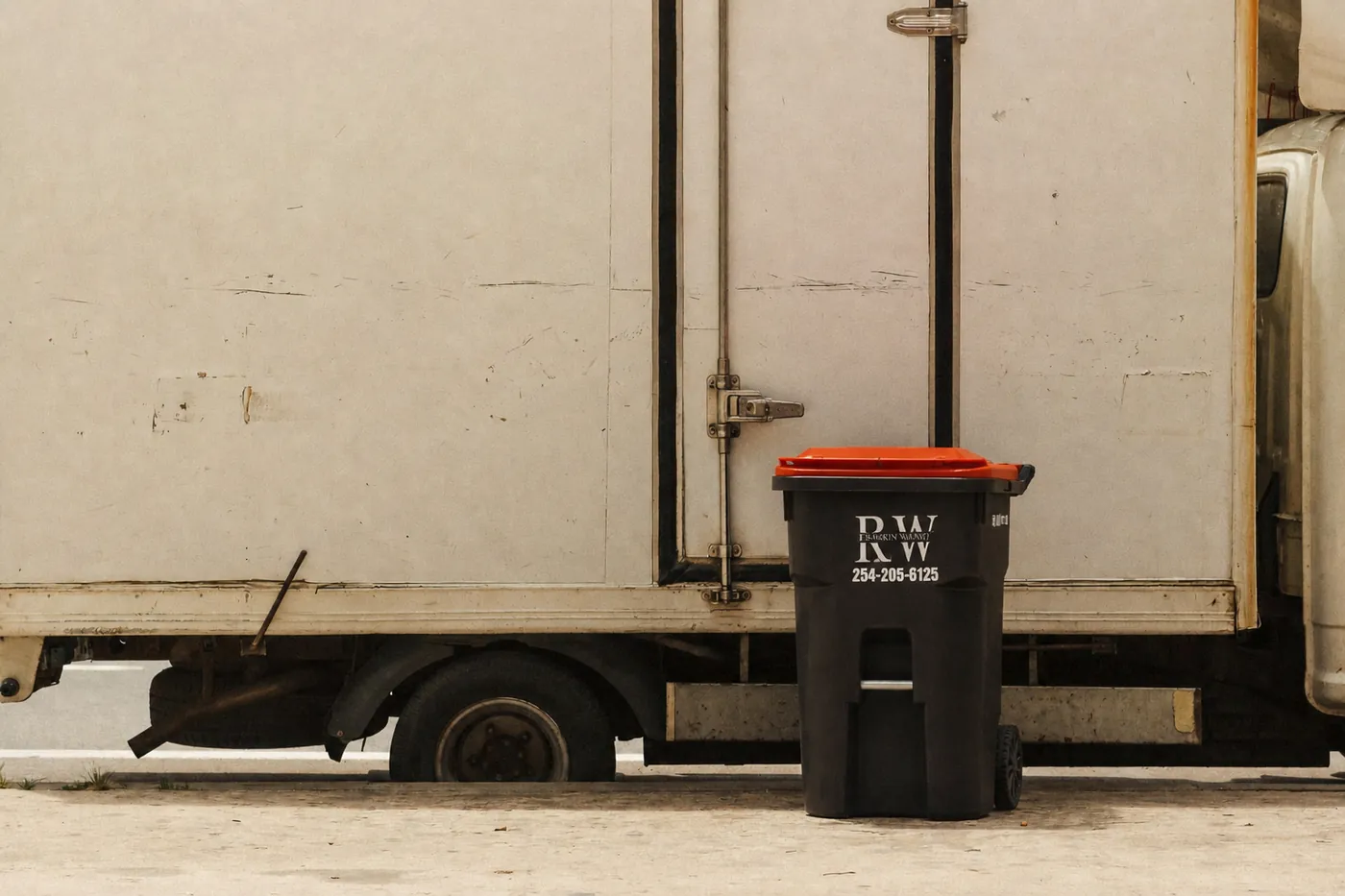 Rankin Waste branded curbside trash bin next to service truck